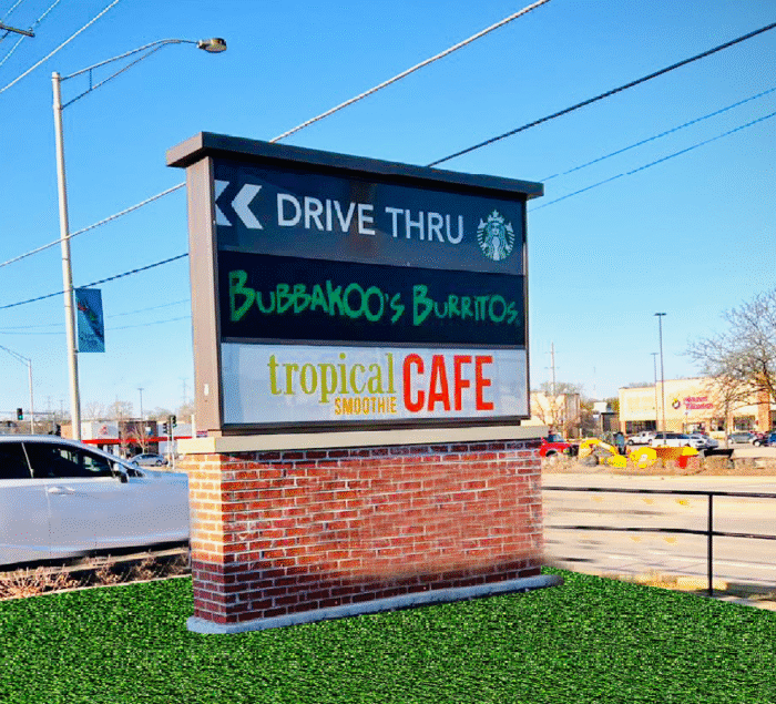 Pylon sign at Chicago shopping mall by SignFreaks, showing drive-through and multiple shops/cafes.